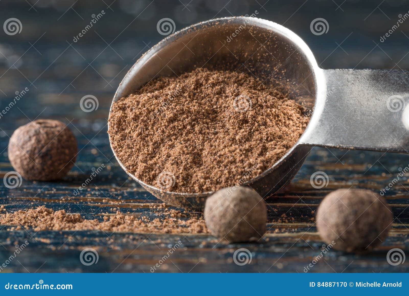 ground allspice spilled from a teaspoon