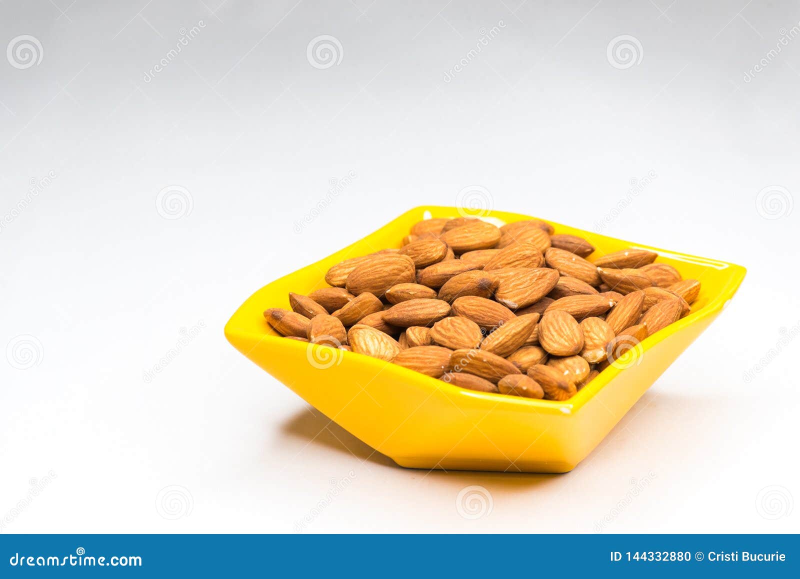 Almonds in yellow bowl stock photo. Image of ingredient - 144332880