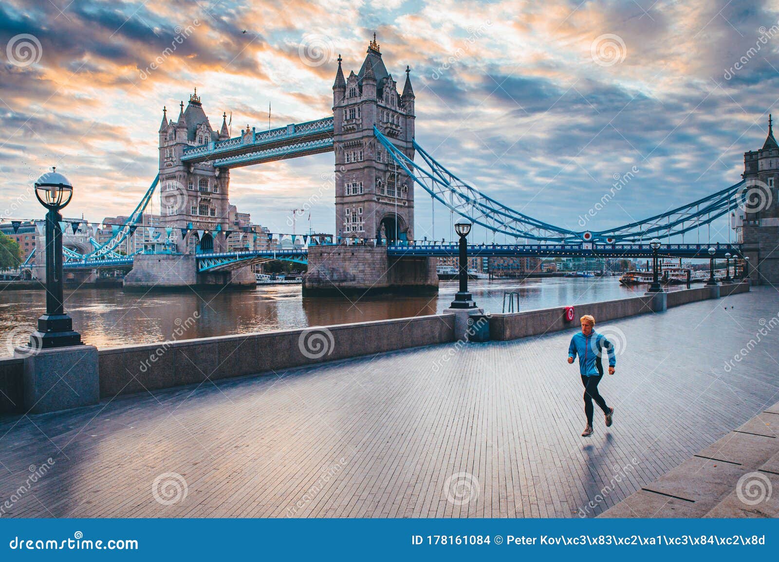 alone runner in empty streets of london in coronavirus, covid-19 quarantine time. tower bridge in background