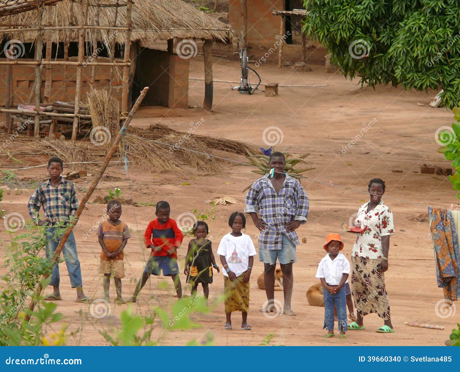 ALT MOLOCUE, MOZAMBIK - 7 2008 GRUDZIEŃ: Najwięcej Afrykańskiej rodziny,. ALT MOLOCUE, MOZAMBIK - 7 2008 GRUDZIEŃ: wioska. Najwięcej Afrykańskiej rodziny, jego rodzice i sześć dzieci stoi na zewnątrz jego w Altowym Molocue do domu, Mozambik - 7 2008 Grudzień. Domy wokoło i budynki.