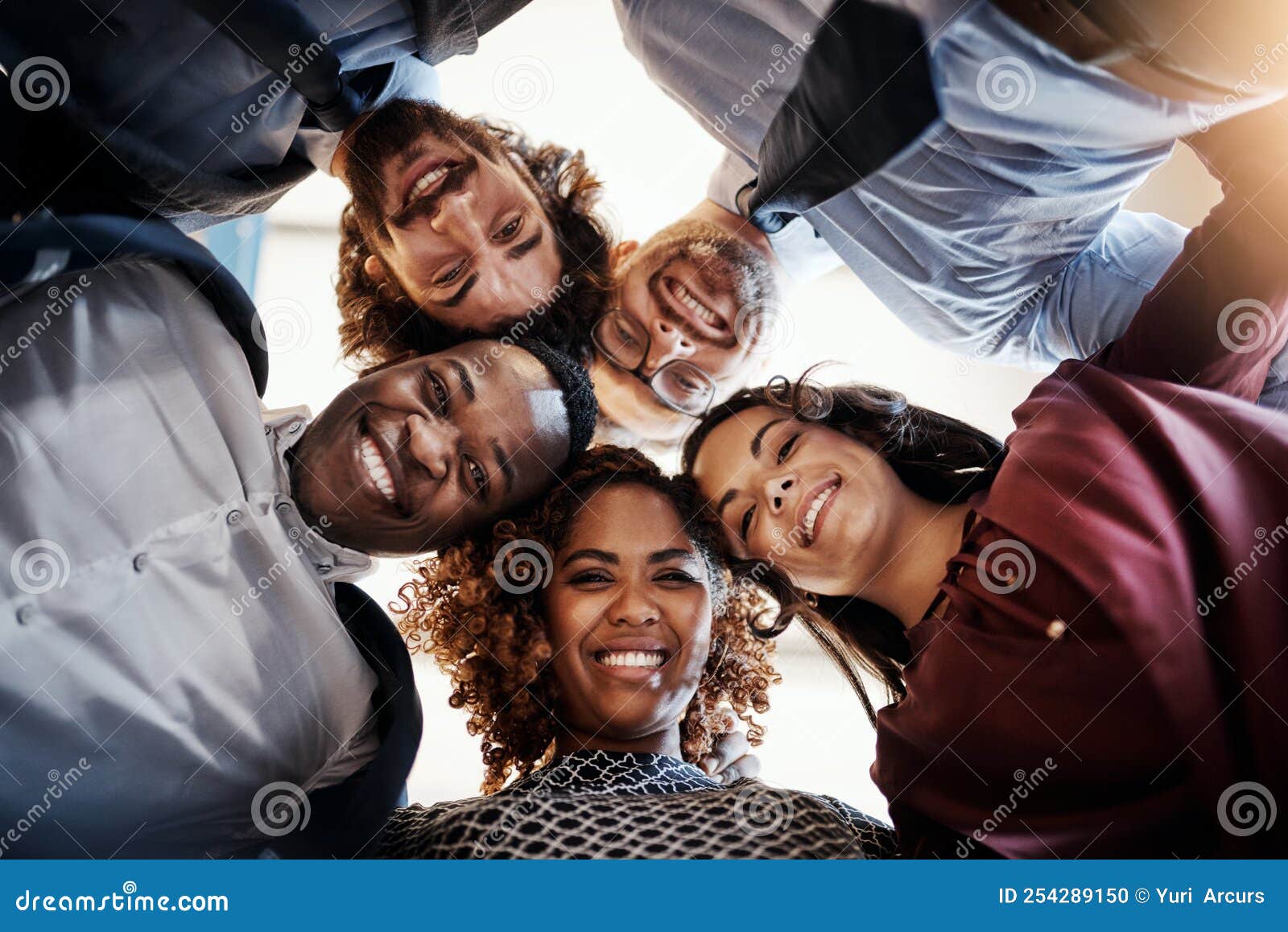 we alway put our heads together. low angle portrait of a team of happy businesspeople putting their heads together in a