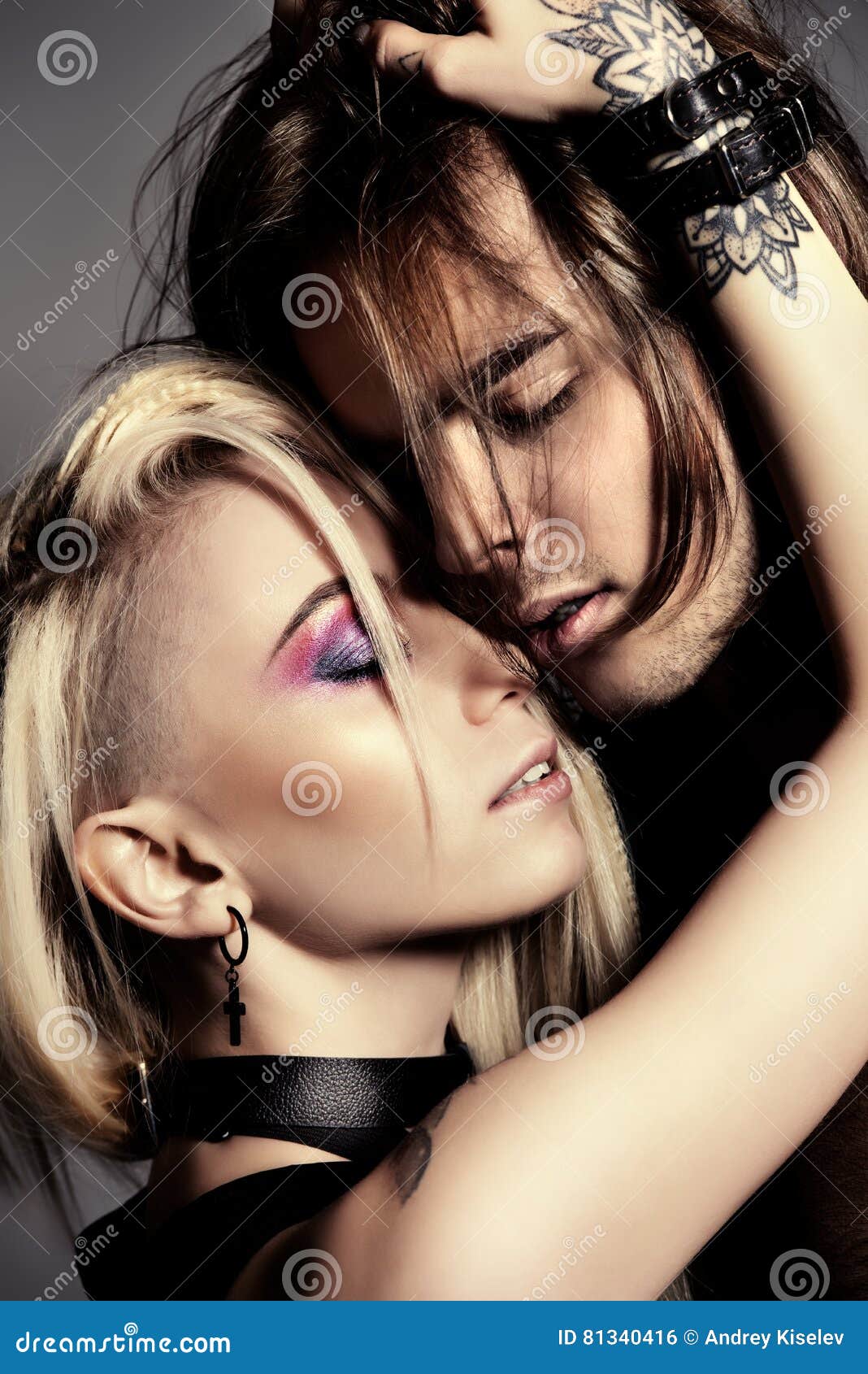Retrato del primer del amantes apasionados Mujeres jovenes atractivas que besan al hombre joven hermoso Maquillaje brillante, cosméticos