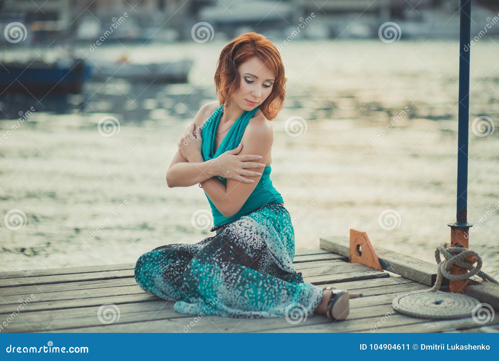 amazing beautifull lady girl woman with red flame hair wearing fancy fashion green clothes posing sitting on wooden pier jetty wth
