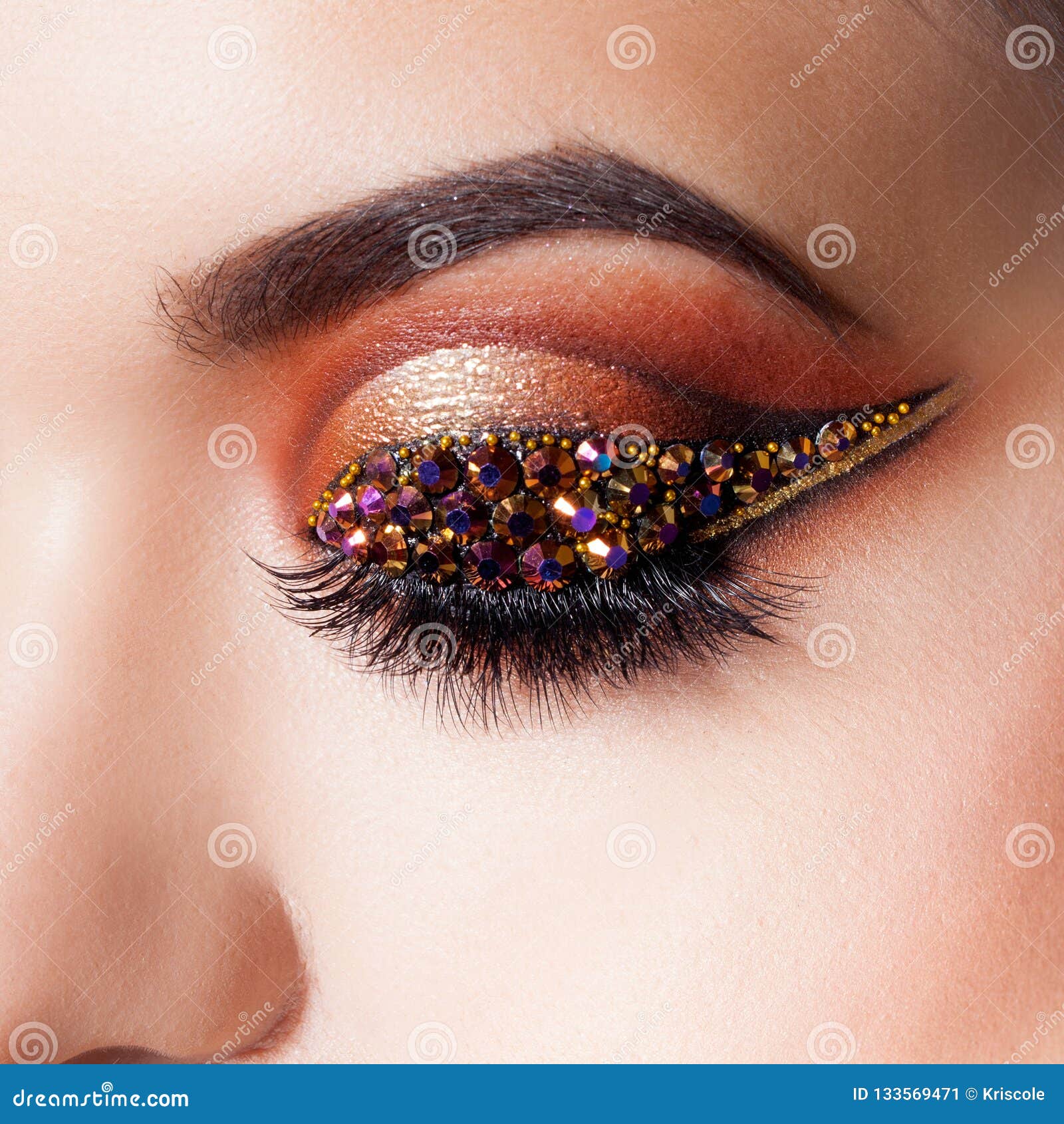 amazing bright eye makeup with a arrow with rhinestones. brown and gold tones, colored eyeshadow