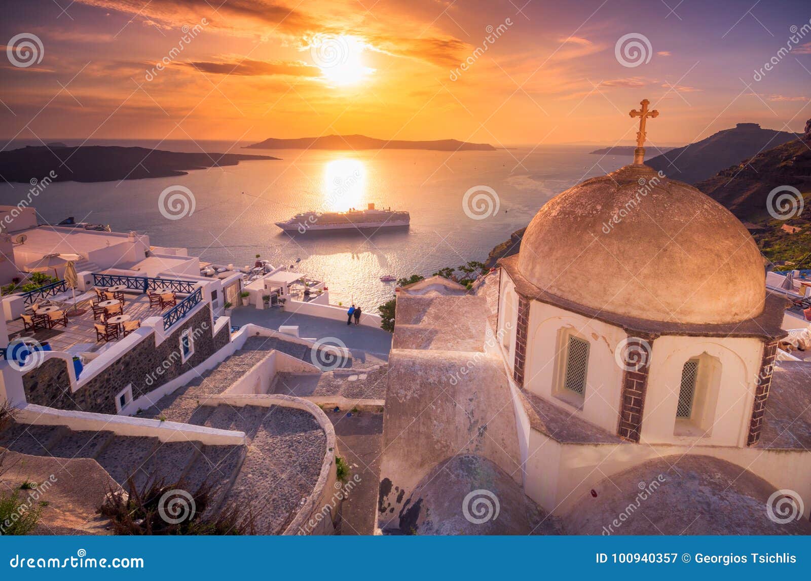 amazing evening view of fira, caldera, volcano of santorini, greece with cruise ships at sunset.