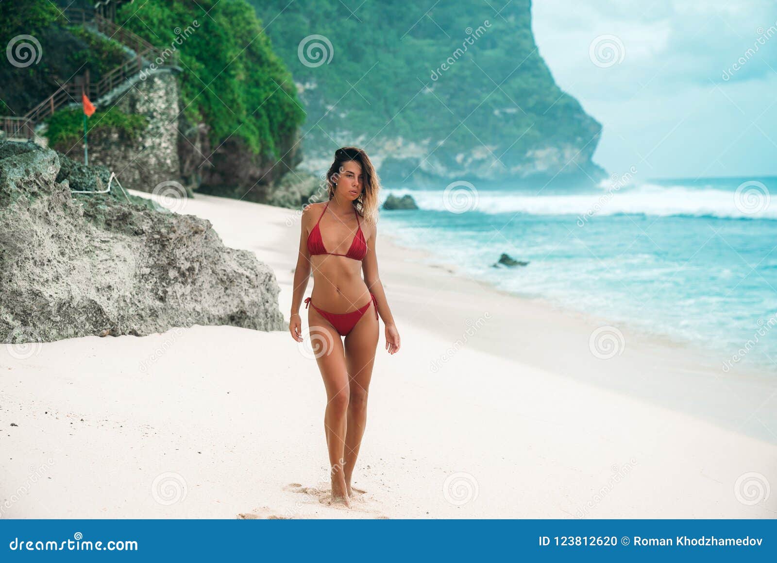 Amazing Girl with Body is Engaged in Fitness on the White Sand Beach