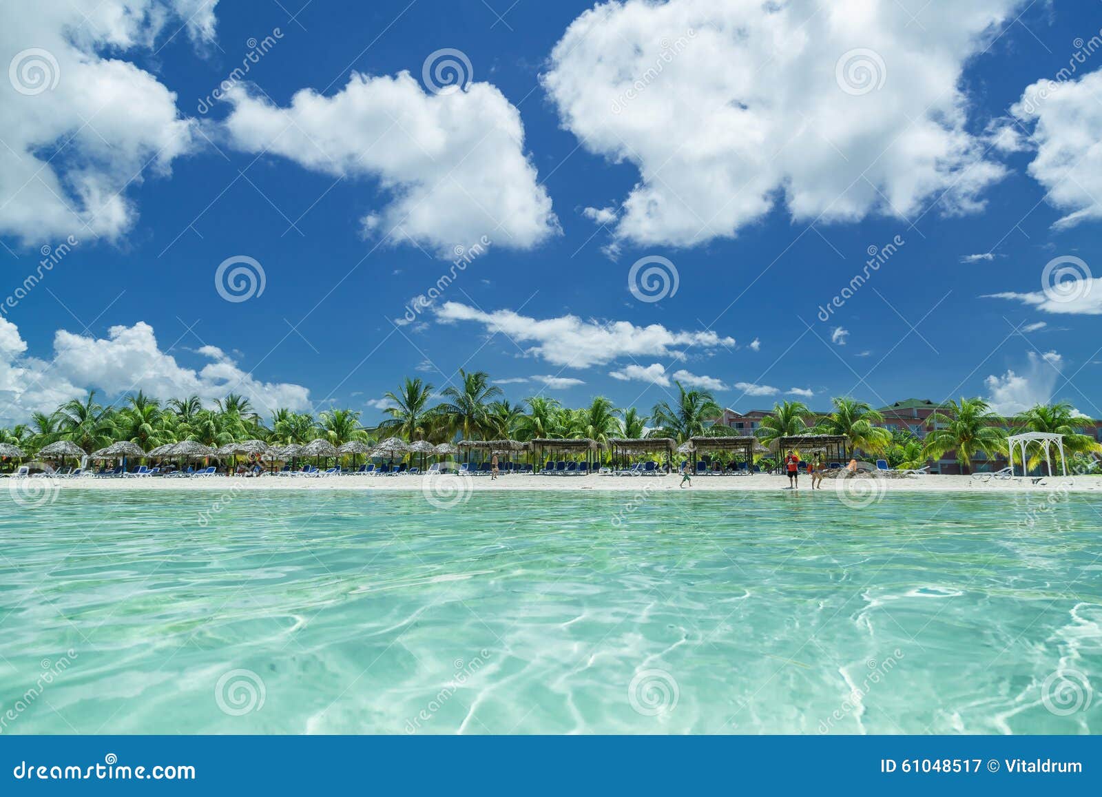 amazing inviting view of cuban, cayo coco beach from the tranquil turquoise ocean side, with people in background