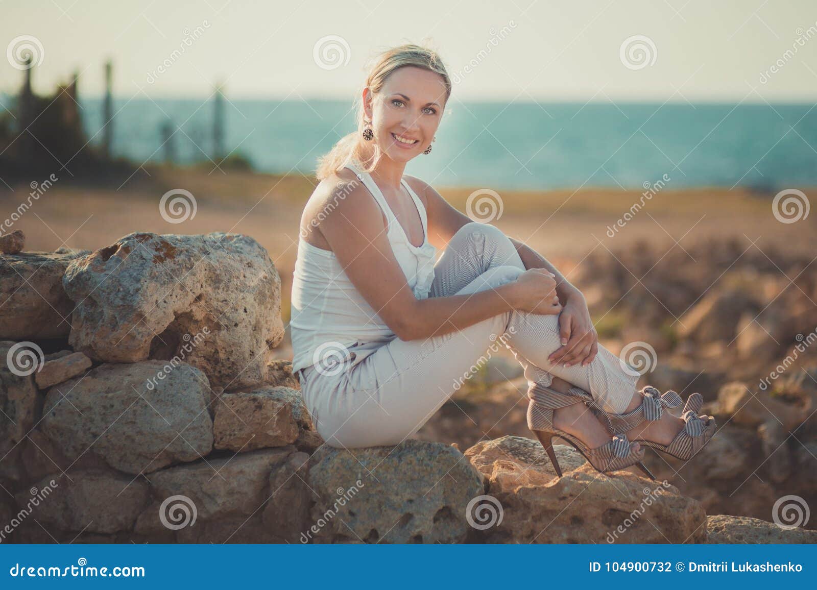 amazing lady blond woman in light white stylish clothes posing on sea side beach air.sparkler girl looking to camera on ancie