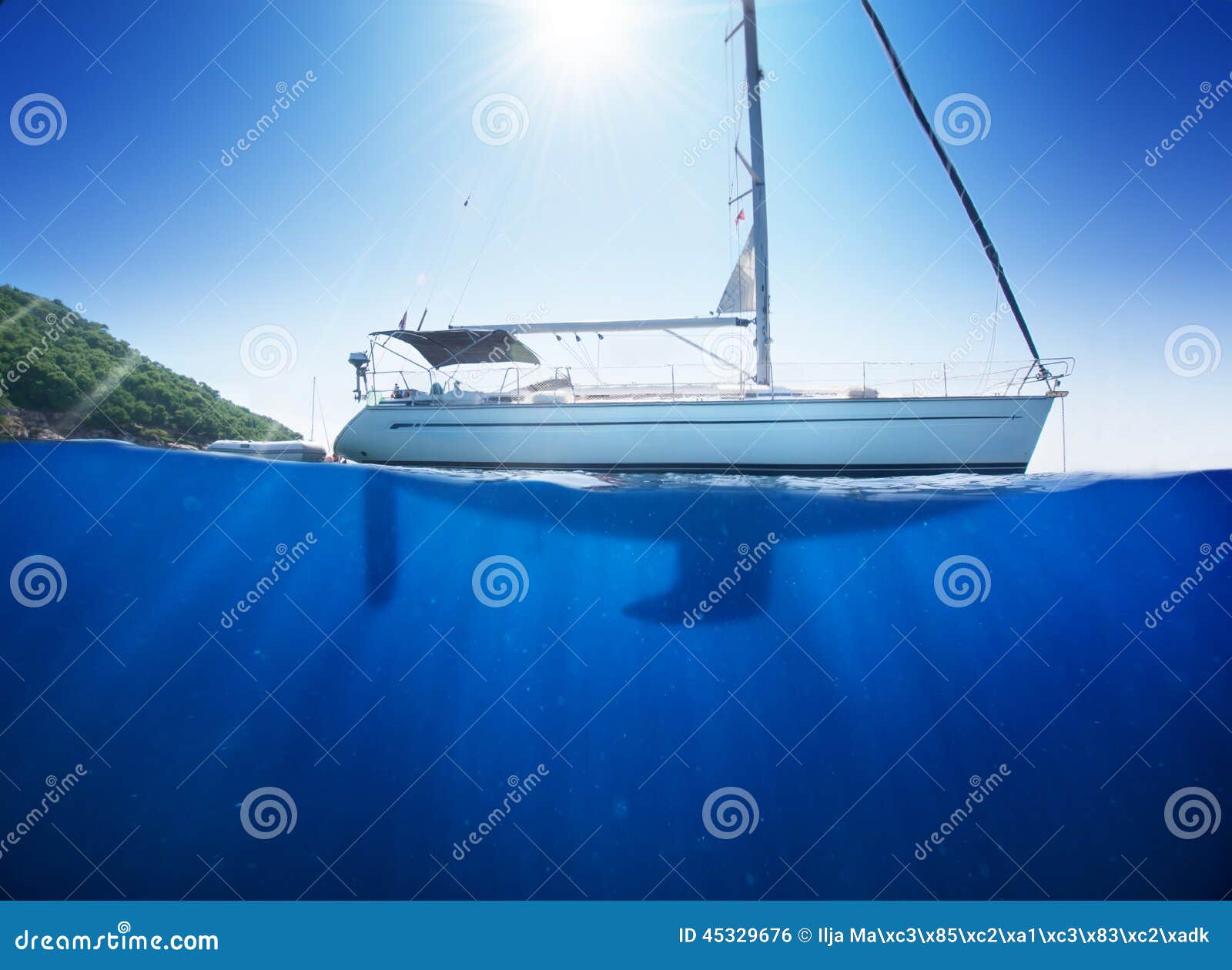 amazing sunlight seaview to sailboat in tropical sea with deep blue underneath splitted by waterline