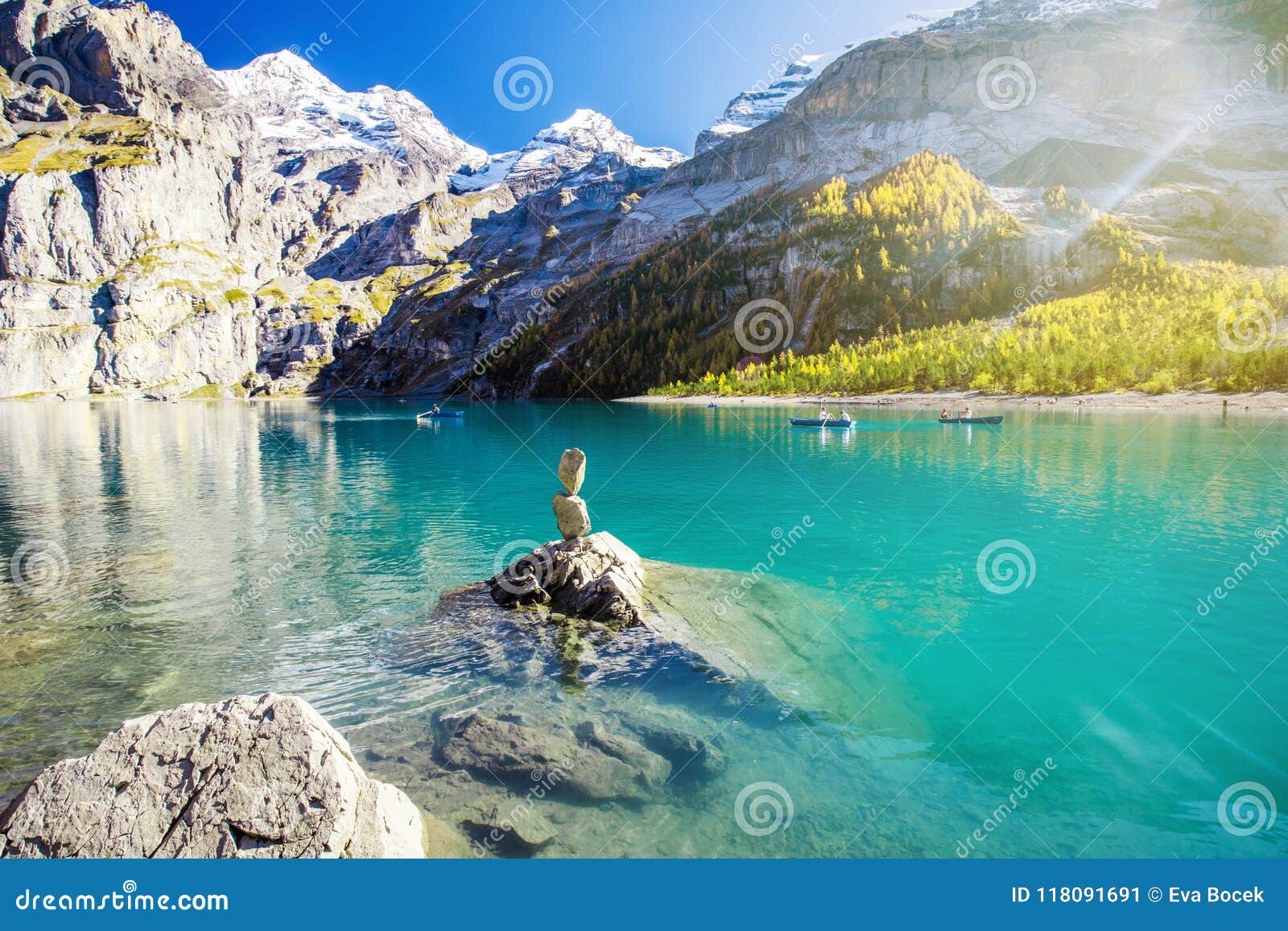 amazing tourquise oeschinnensee with waterfalls, wooden chalet and swiss alps, berner oberland, switzerland