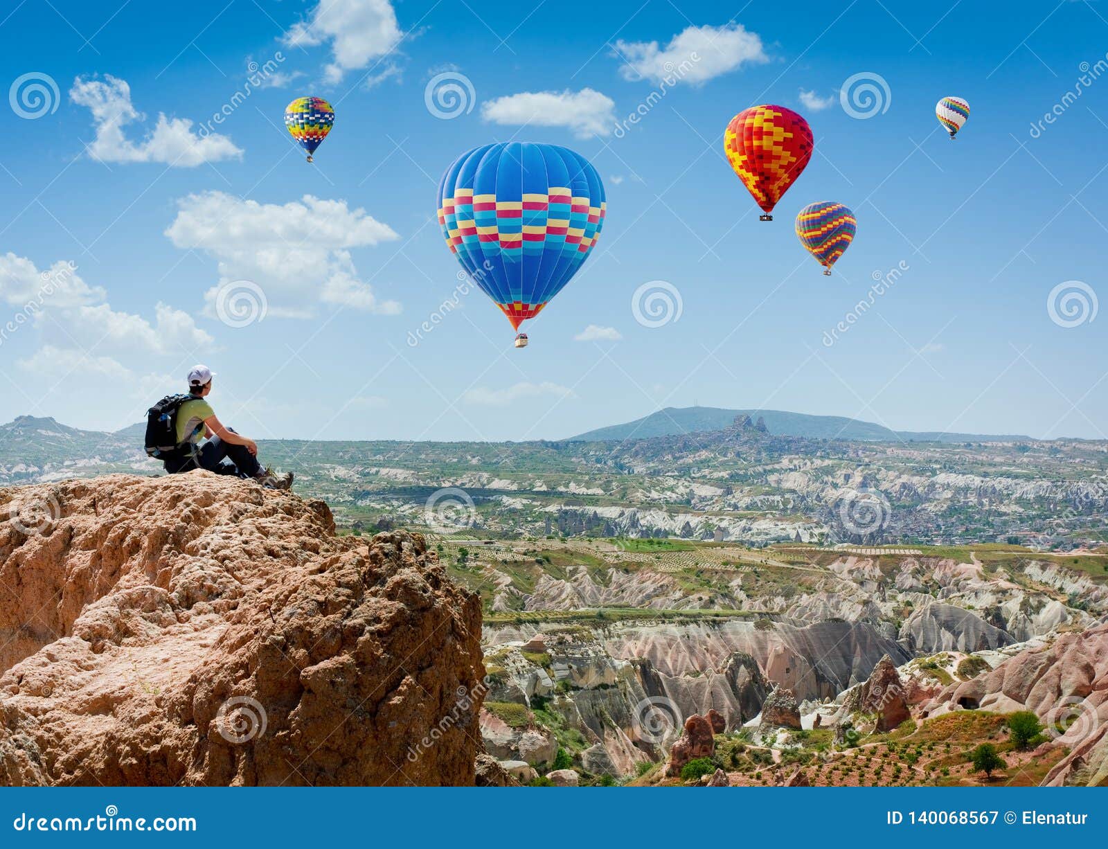 amazing view with sport sitting girl and a lot of hot air balloons. national park anatolia, cappadocia, turkey. artistic picture