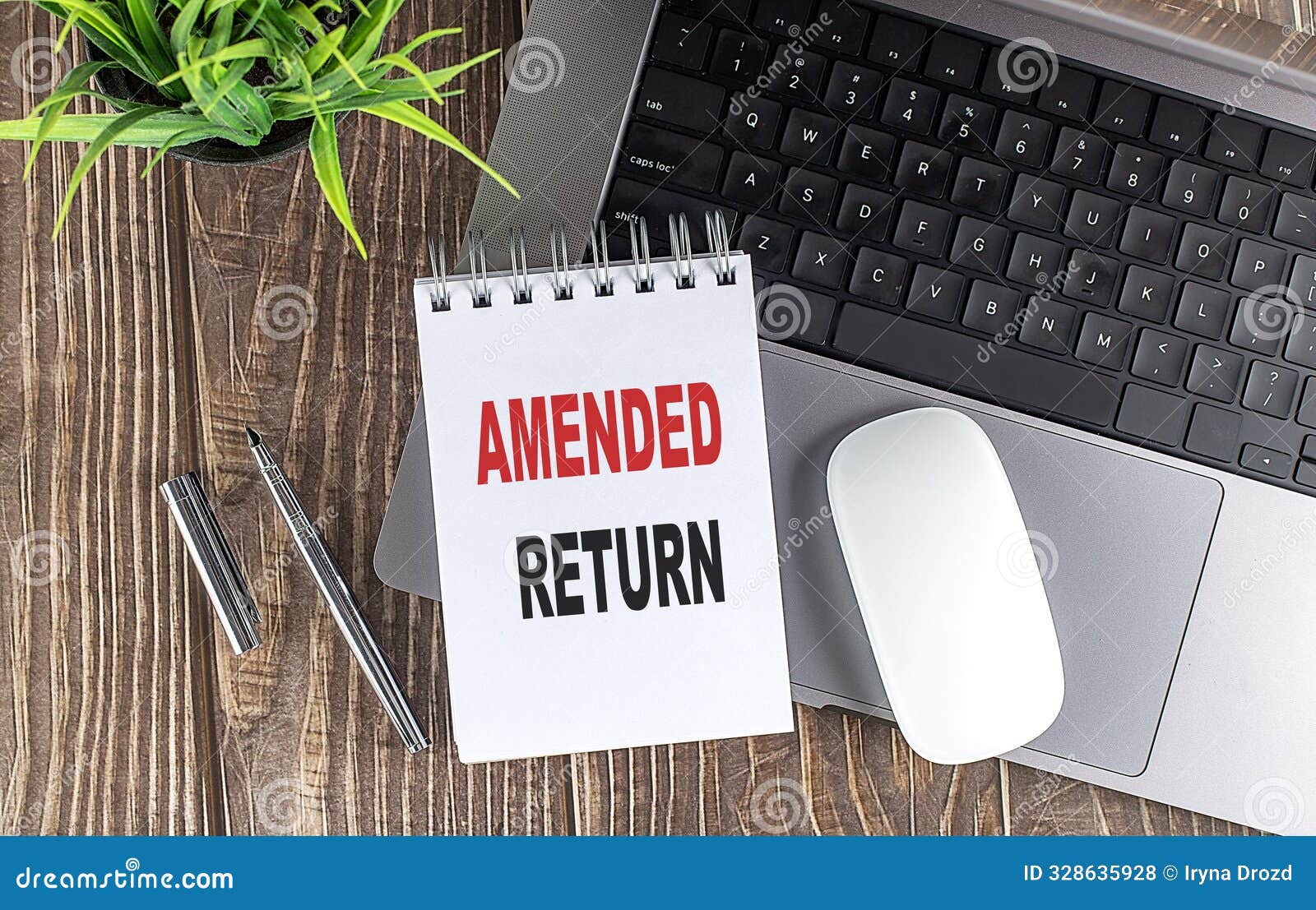 amended return text on a notebook with laptop, mouse and pen .
