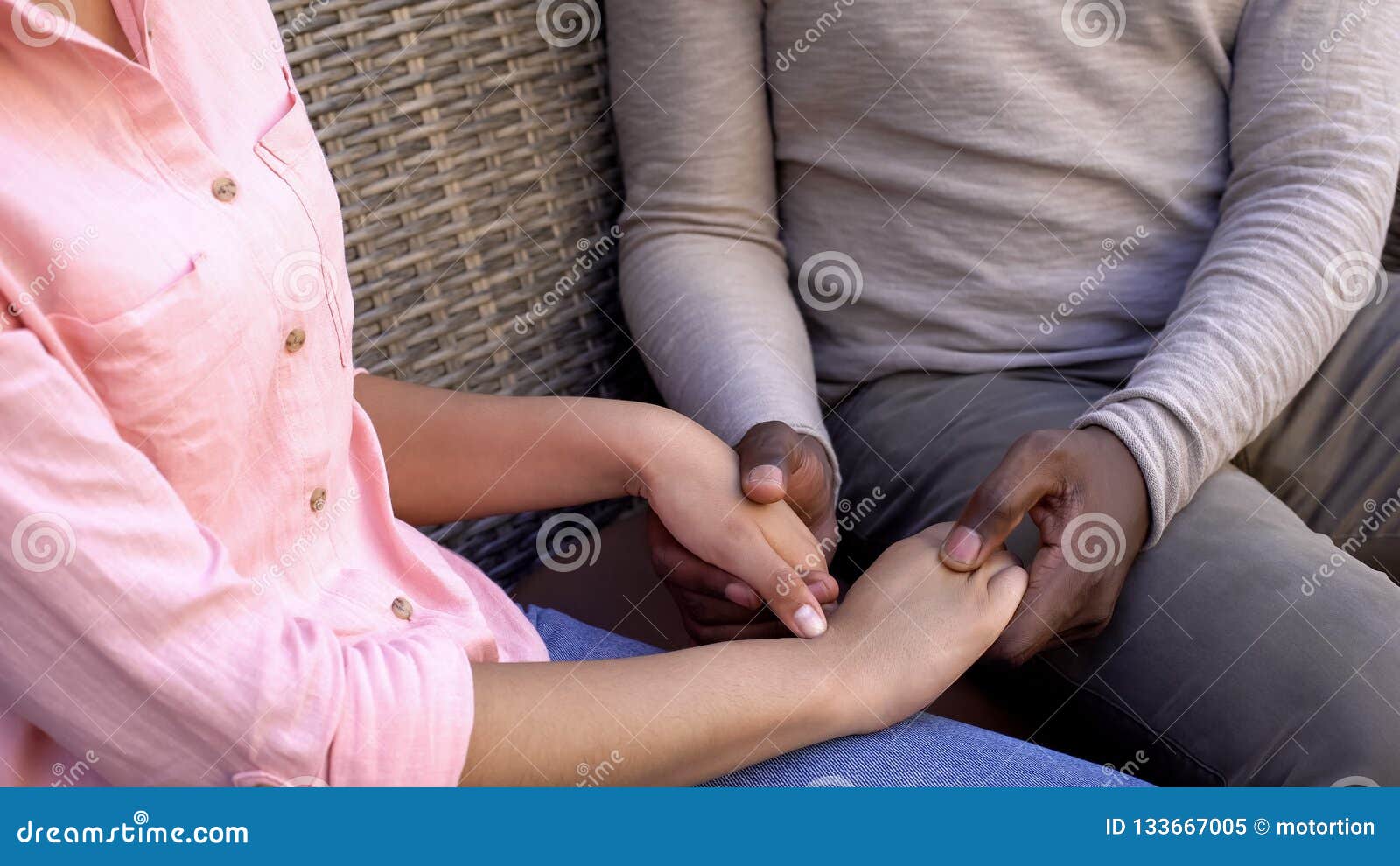 american loving couple holding hands sitting on bench, trusting relationships
