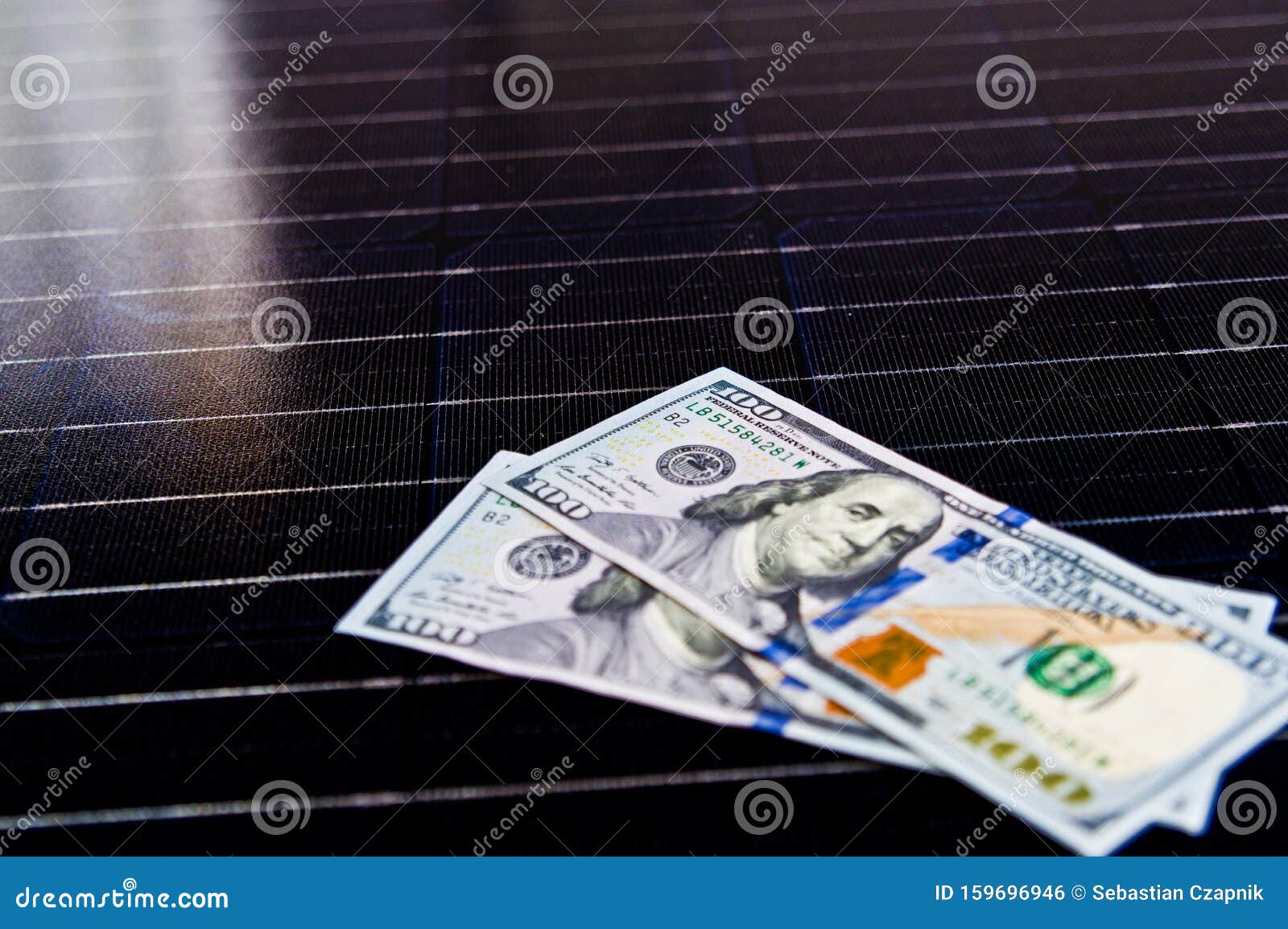 american money on solar panel surface. renewable energy cost