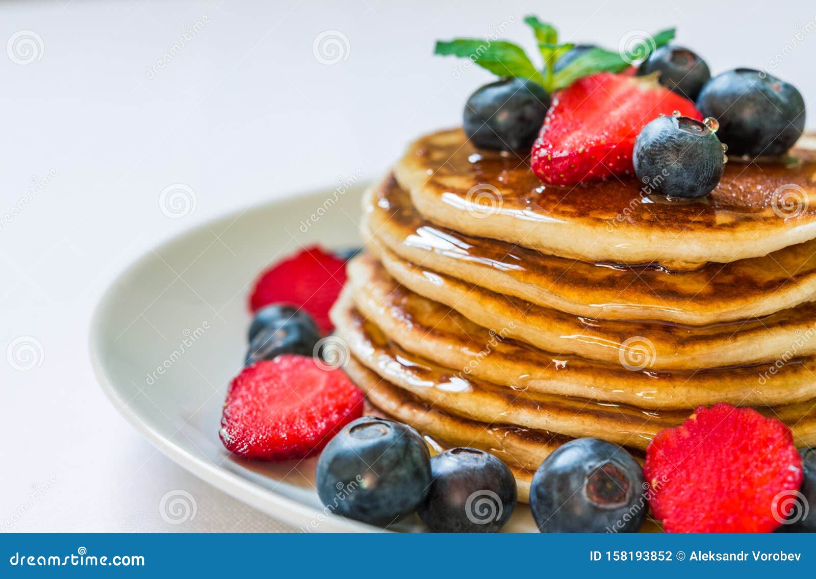 American Pancakes with Honey Against White Background. Stock Photo