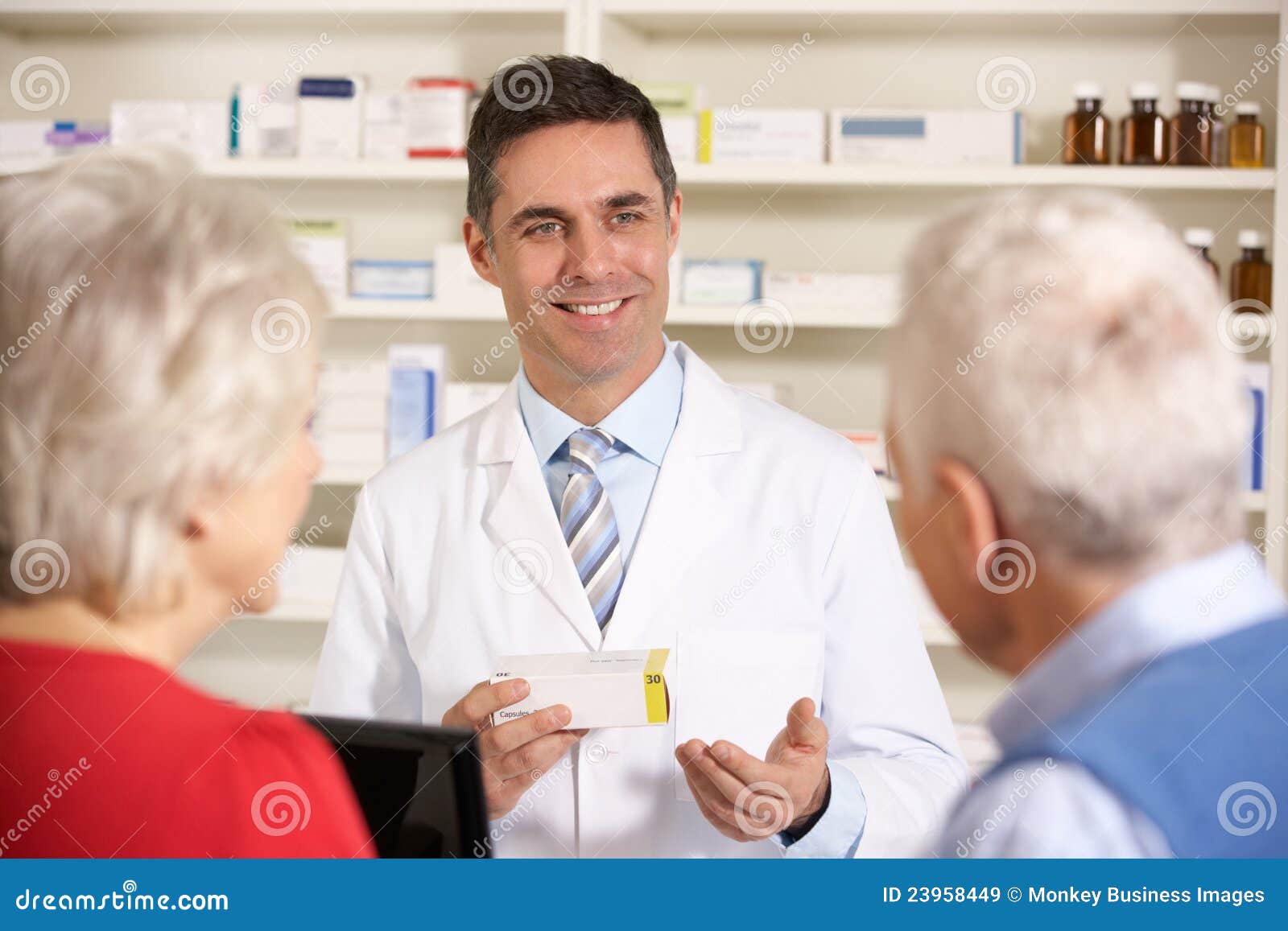 american pharmacist with senior couple in pharmacy
