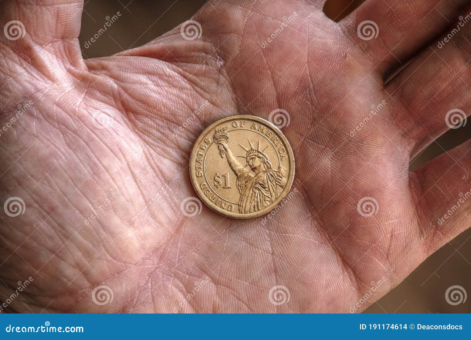american us coin 1 dollar buck lie on a dirty palm close up. an impressive, dramatic shot with an aged effect. low-wage labor work