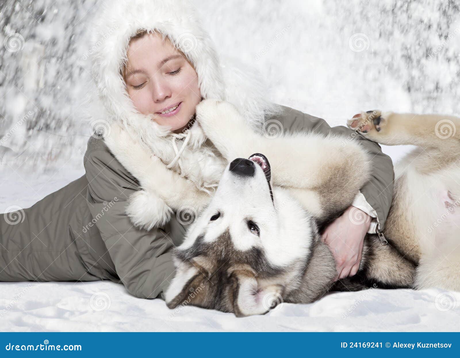 Amigos. Juego caucásico joven de la mujer con un perrito del malamute