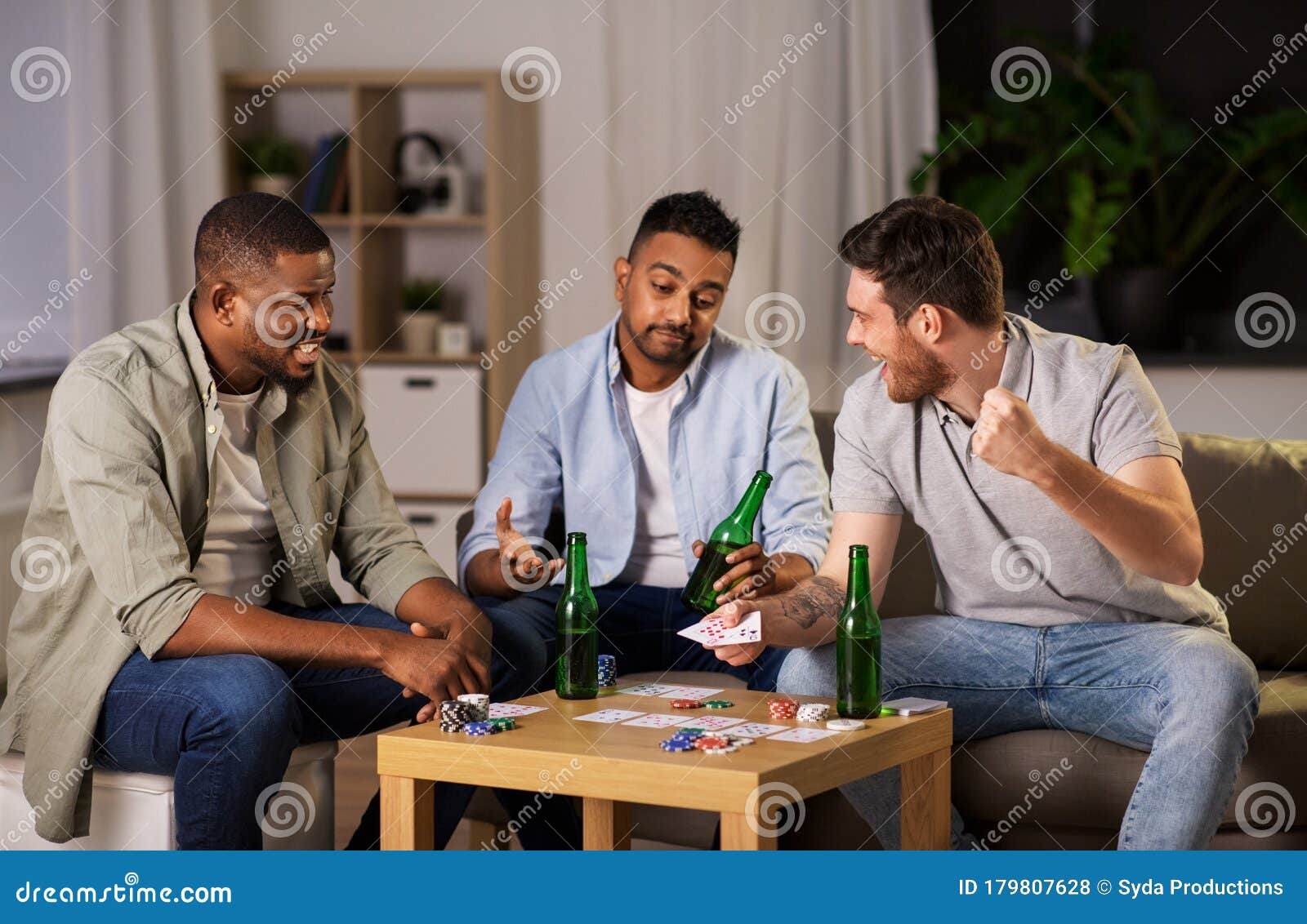 Amigos Homens Felizes Jogando Cartas Em Casa à Noite Foto de Stock