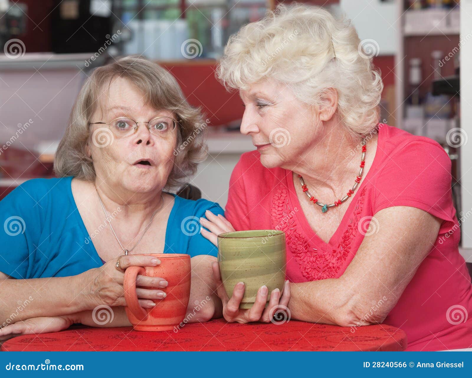 Amigos interessados que falam no café. Mulheres mais idosas surpreendidas que falam com seu amigo em um café