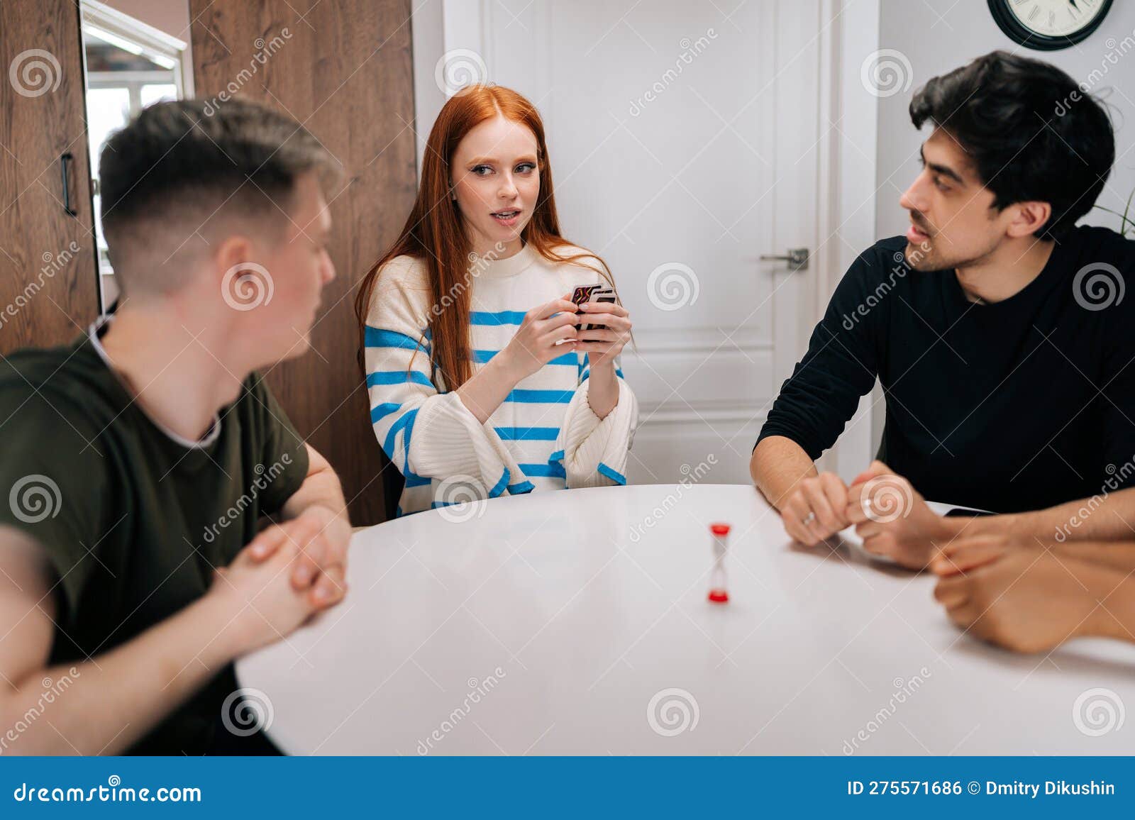 Jovem bonito sério jogando jogos de cartas divertidos contando associações  para diversos amigos desfrutando de atividade de passatempo sentado à mesa  em casa