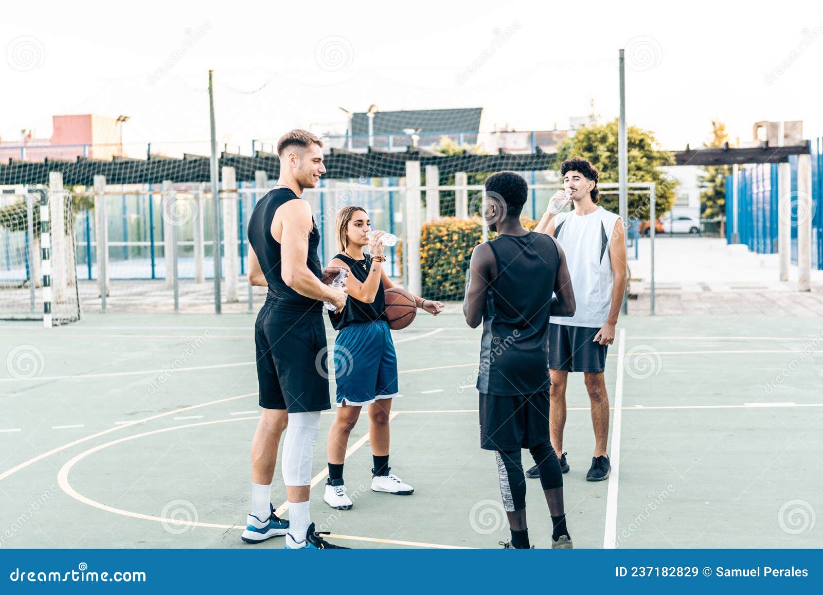 Grupo de pessoas multiétnicas jogando basquete na quadra