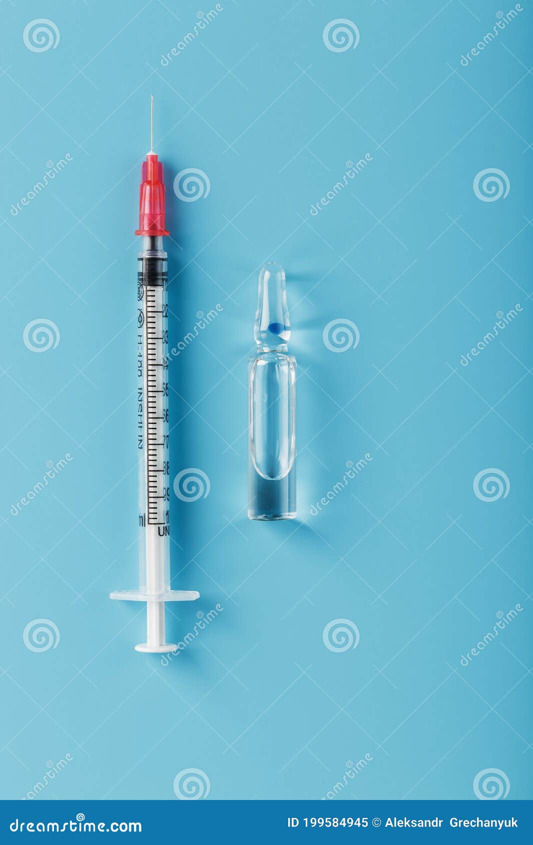 ampoule with medicine and syringe on a blue background, top view