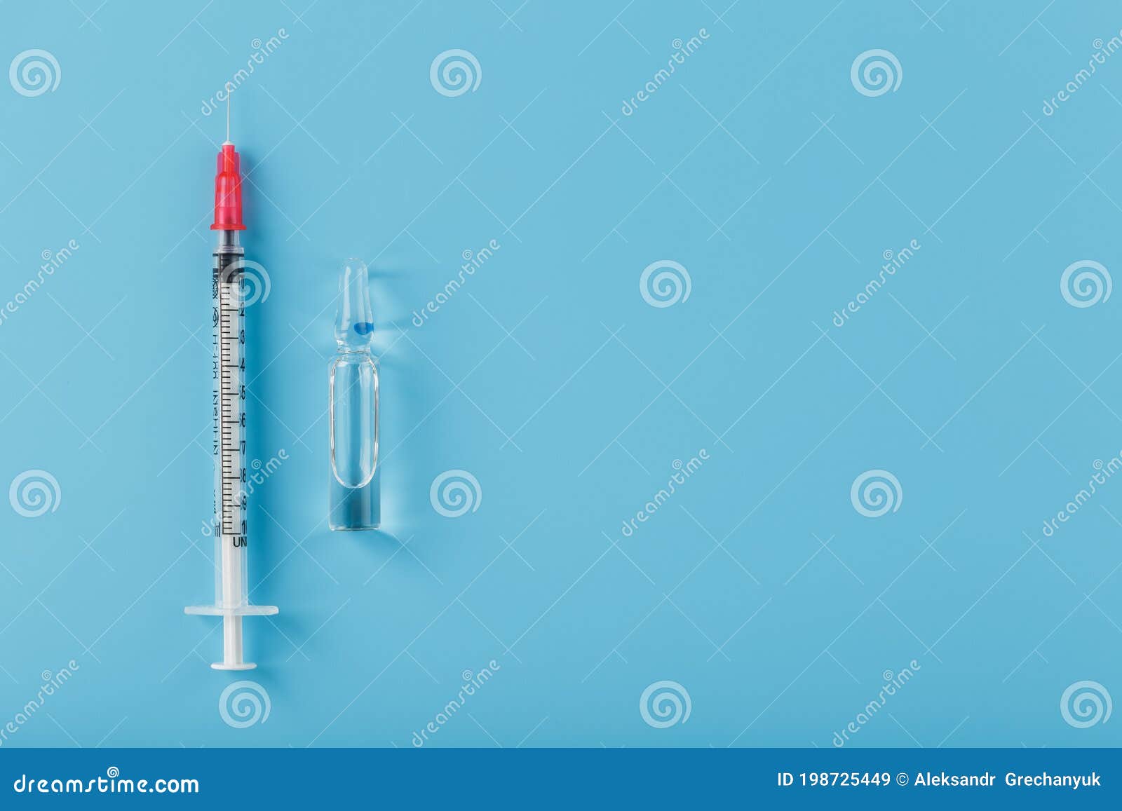 ampoule with medicine and syringe on a blue background, top view.