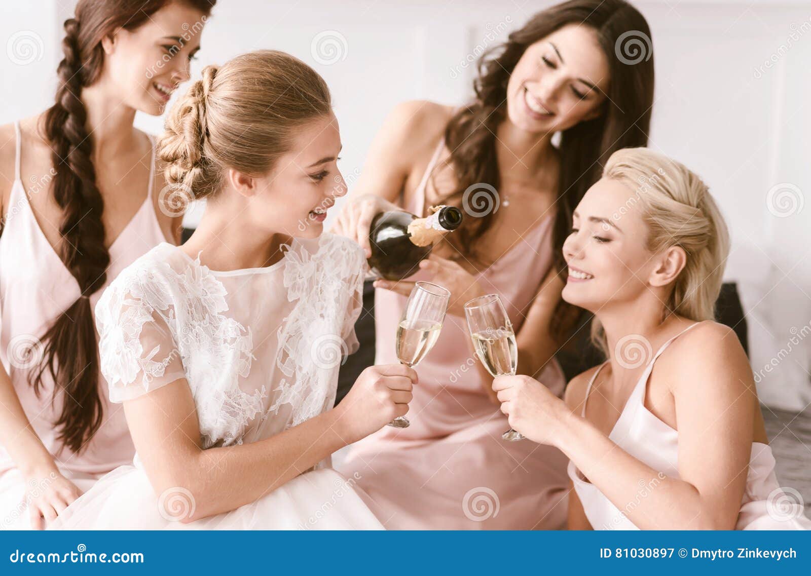 amused bride and bridesmaids having hen party at home