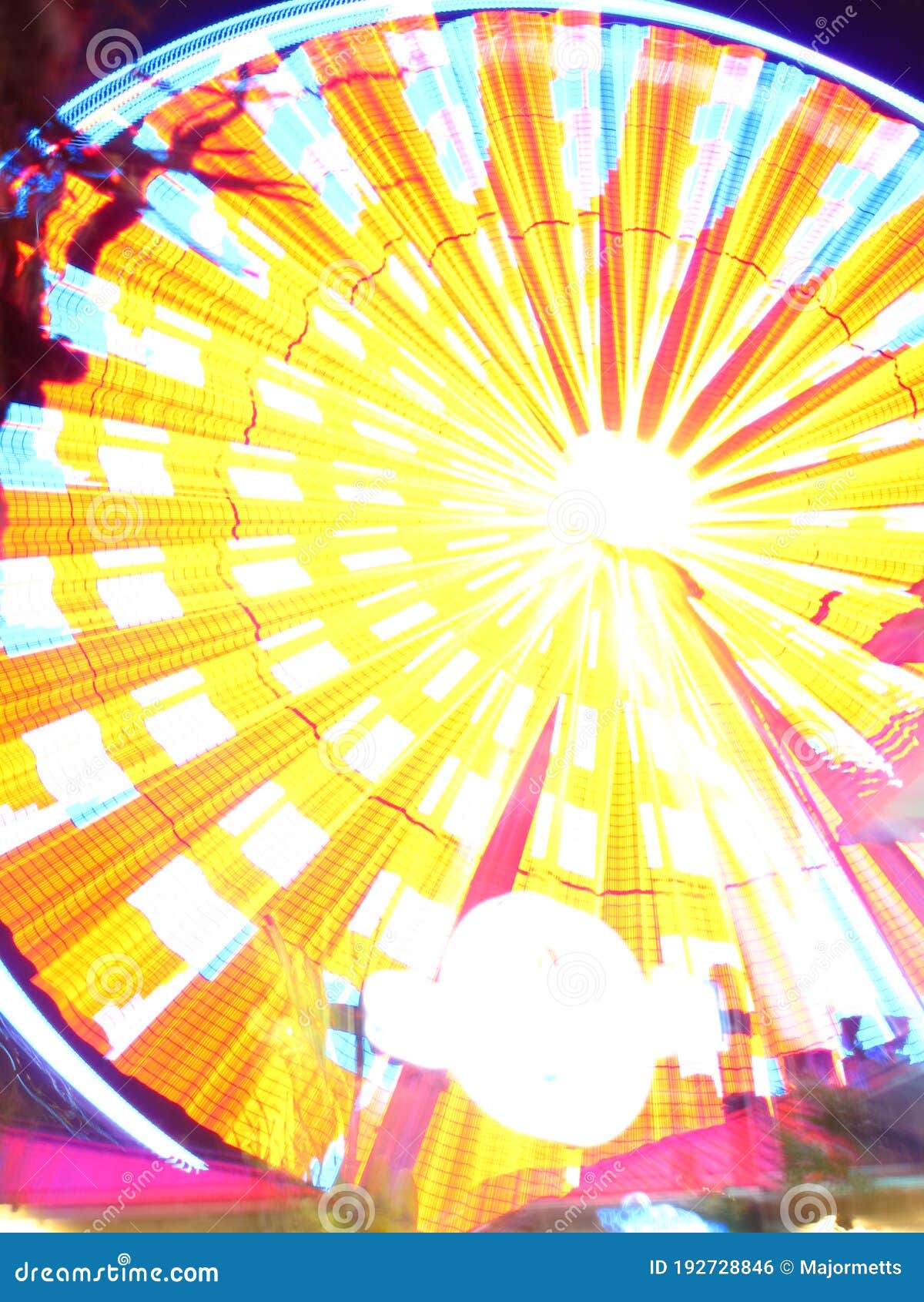 amusement park ferris wheel with blurred multicolored lights, vertical orientation
