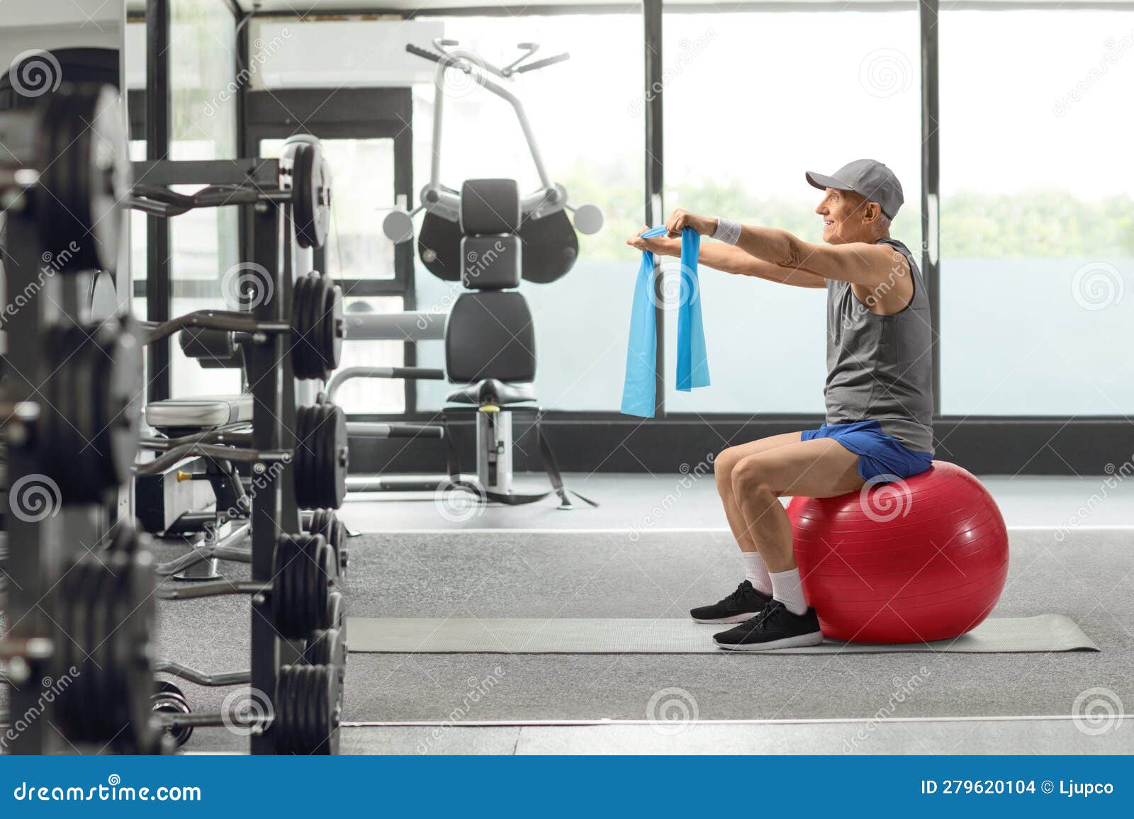 Hombre en ropa deportiva haciendo ejercicio con un balón medicinal crossfit  en un gimnasio