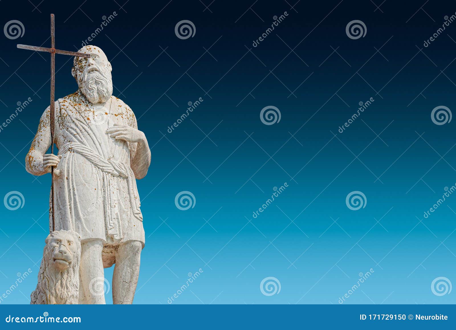 ancient aged sculpture of poor stranger pilgrim with cross and sitting lion at roof of santa maria assunta jesuits church in