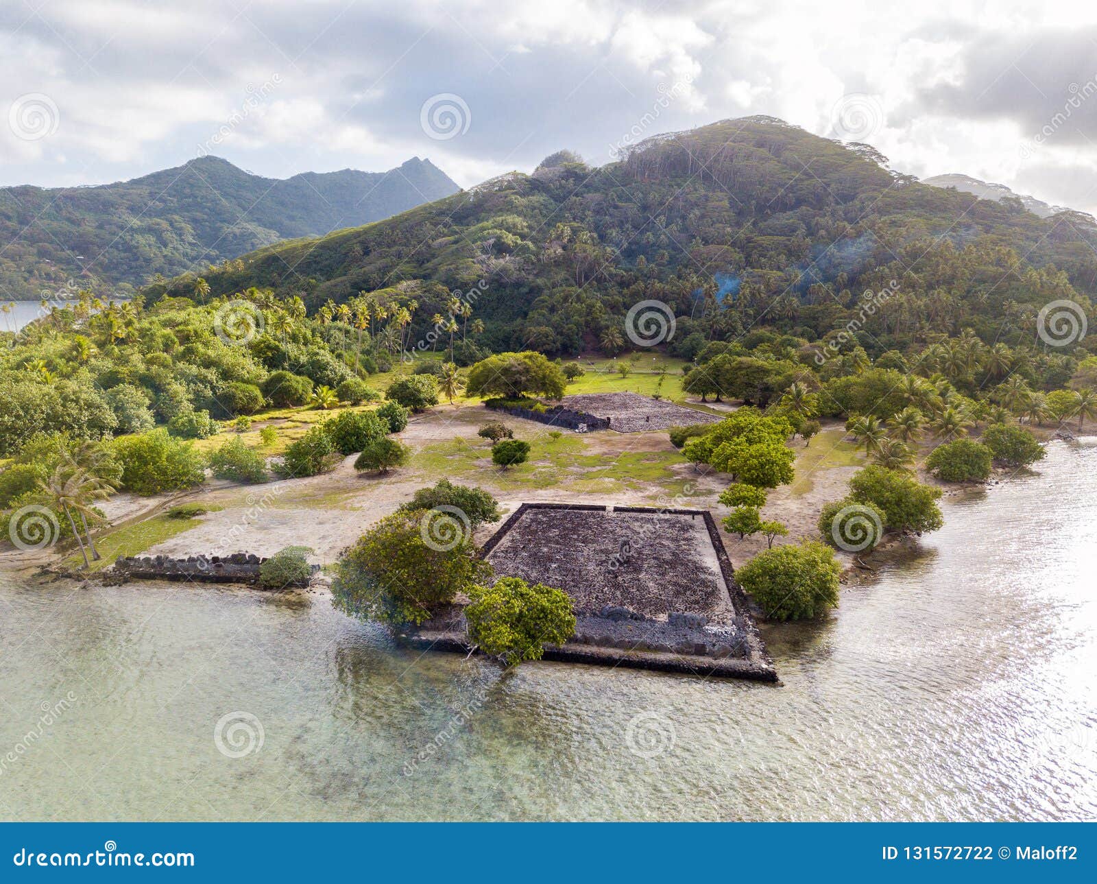ancient marae taputapuatea temple complex, lagoon shore with mountains background. raiatea island. french polynesia, oceania.