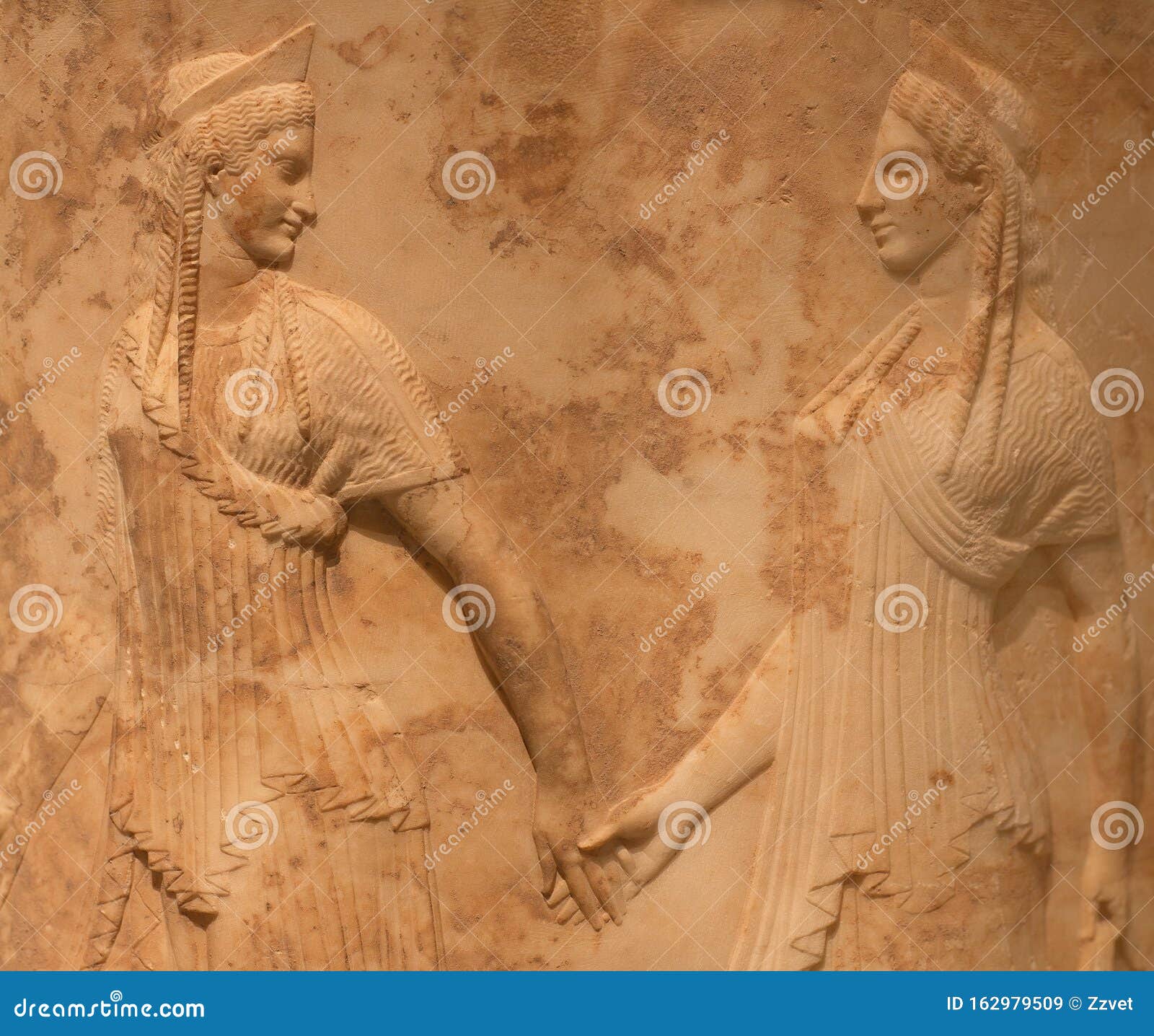 ancient greek bas-relief with two female figures, nymphs or graces holding hands and dancing