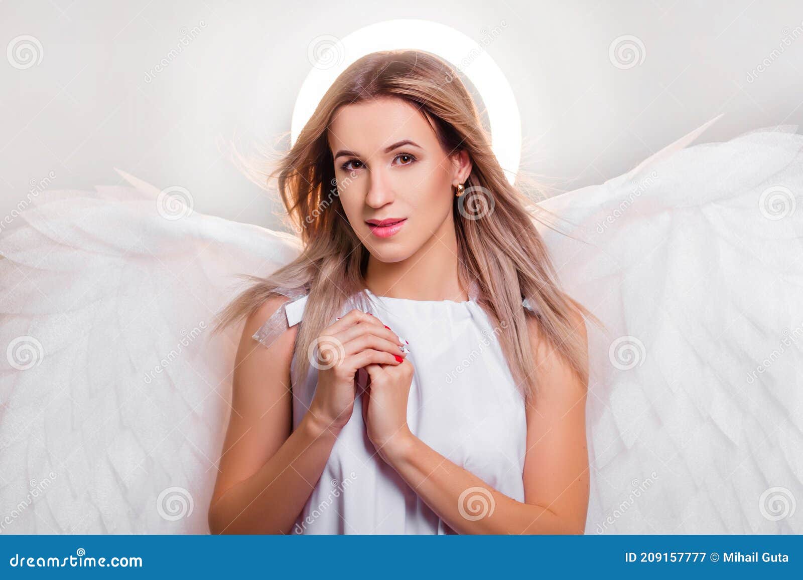 Angel in a White Dress with Large White Wings Behind His Back and a ...