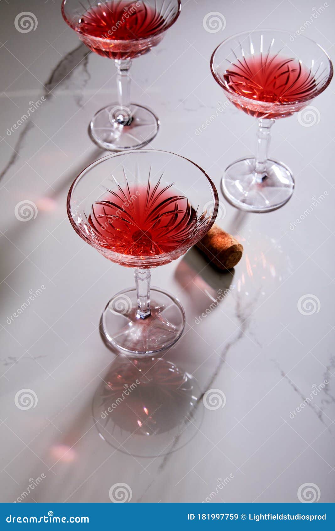 Angle View of Glasses of Cocktail and Cork on White Background Stock