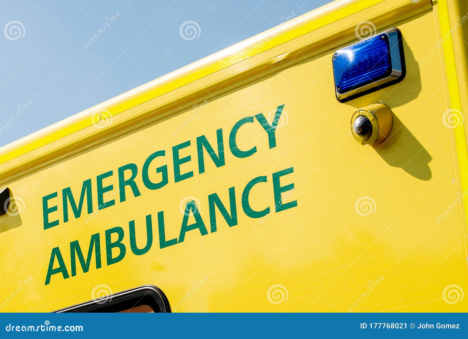 angled view of emergency ambulance sign on yellow nhs vehicle.