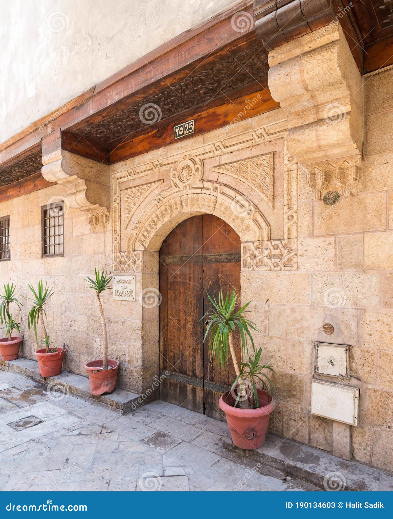 stone bricks wall with arched wooden door of house of moustafa gaafar al selehdar, cairo, egypt
