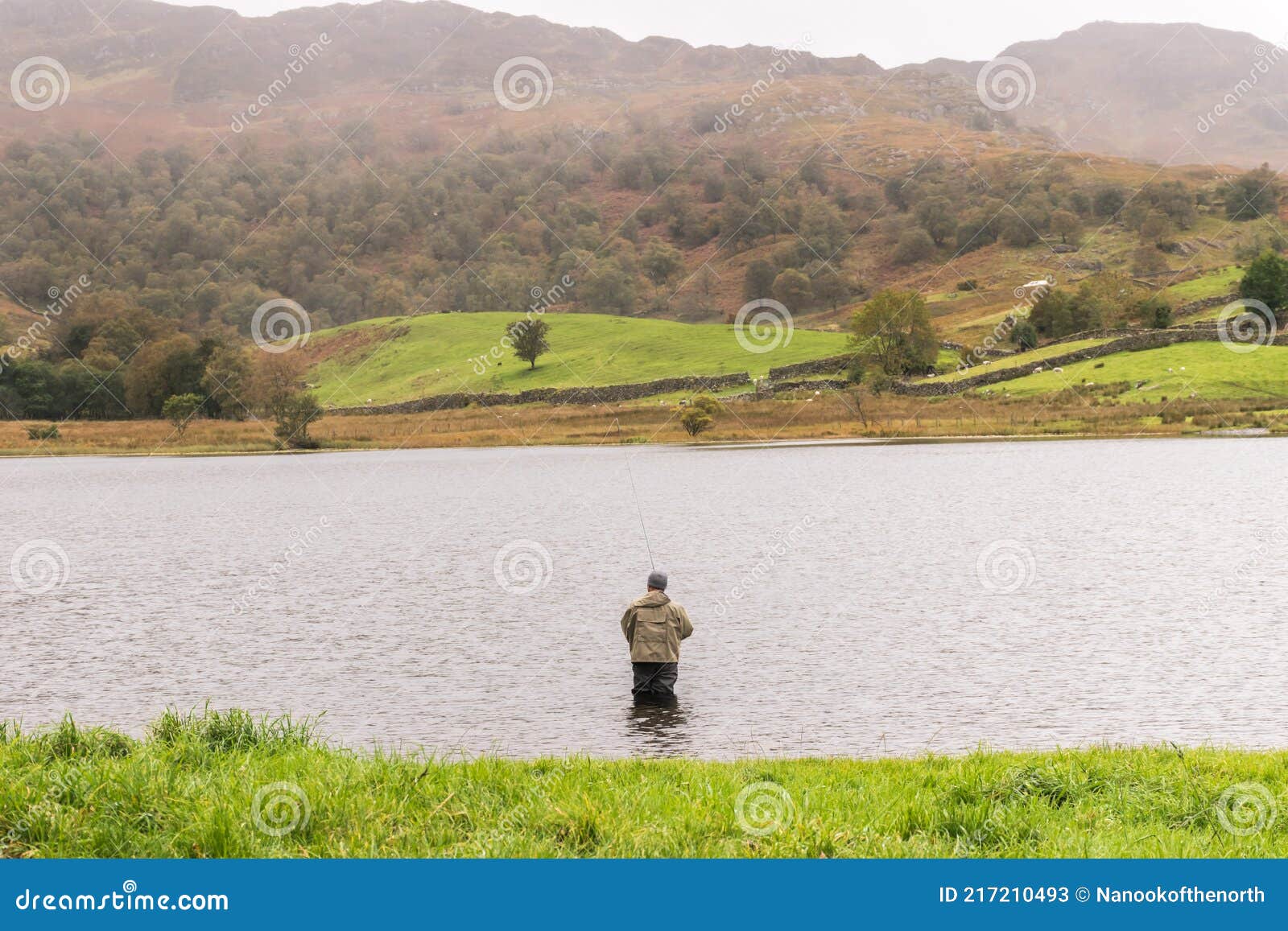 angler in waders waiting for a catch at watendlath