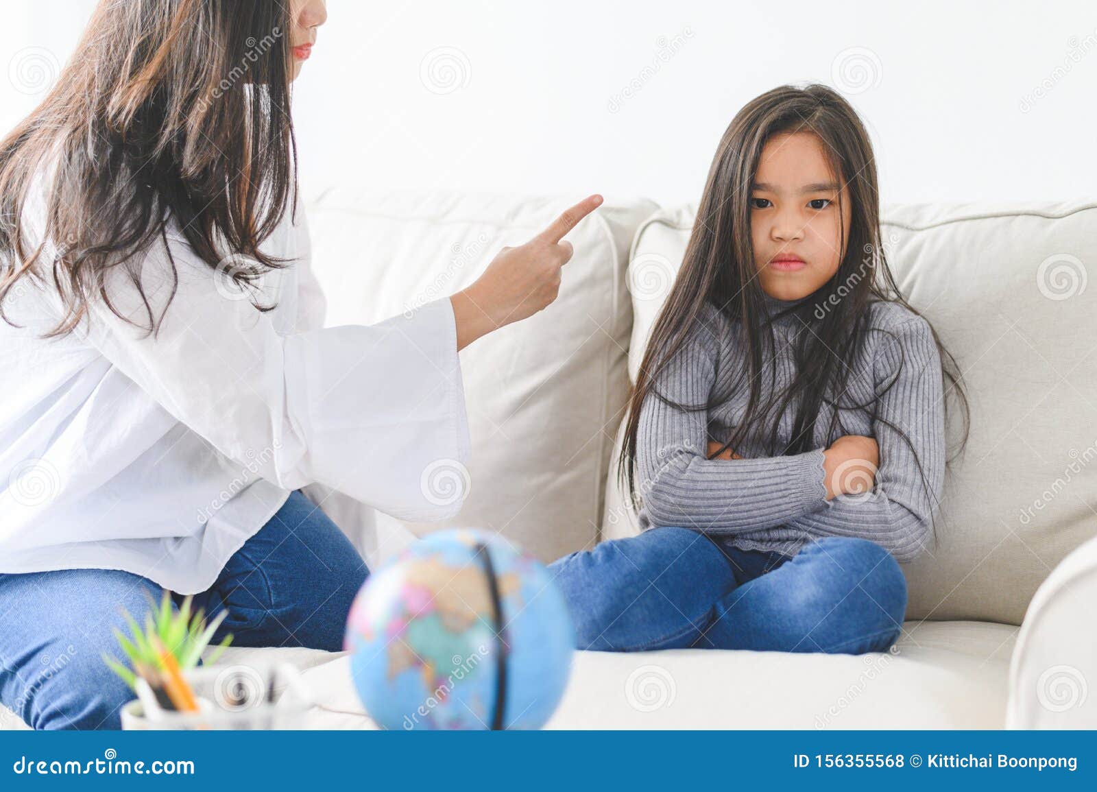 angry asian mother sitting with little daughter , mom scolds for discipline bad behaviour capricious kid, family generations