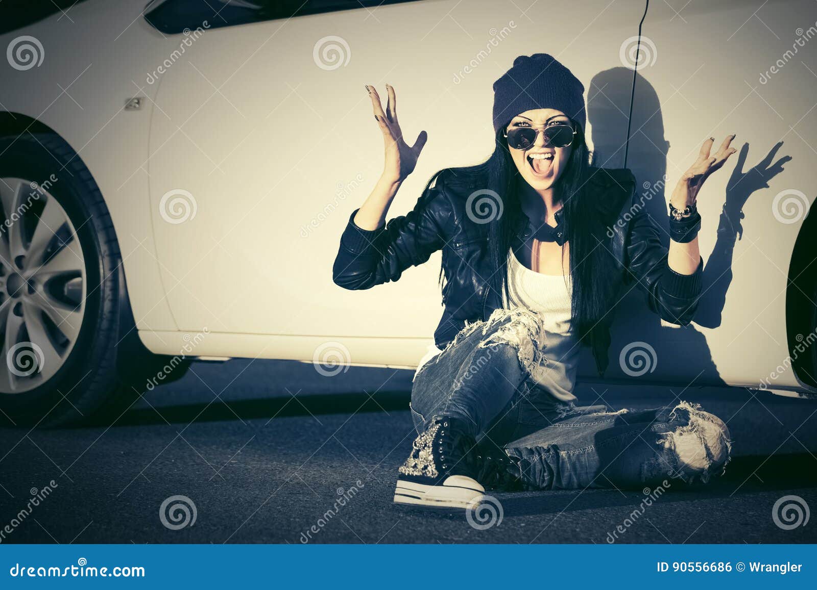 angry fashion punk woman sitting next to her car