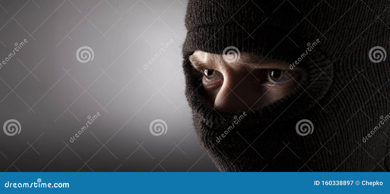 angry man in a balaclava on a dark background