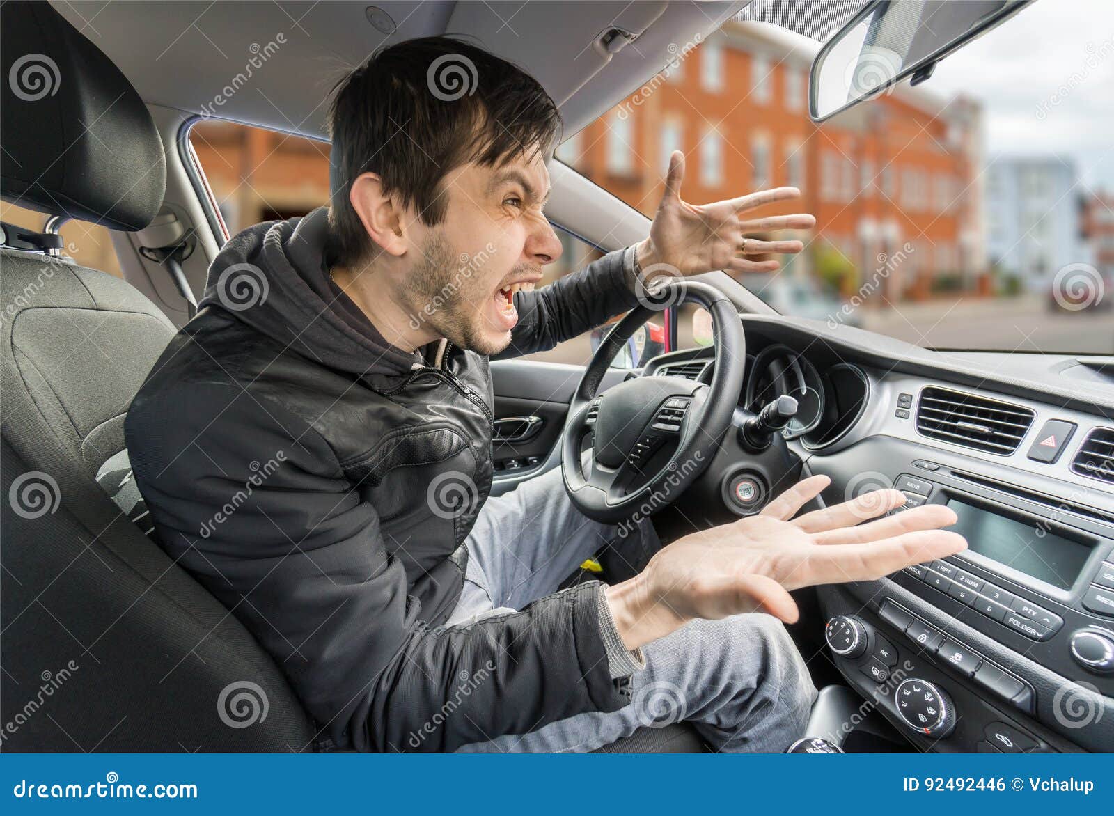 angry young driver is driving a car and shouting