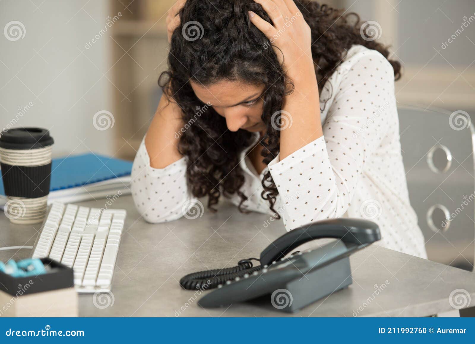 anguished woman at desk with head in hands