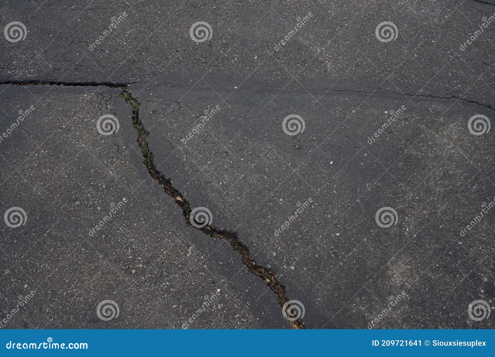 angular deep crack in dark pavement