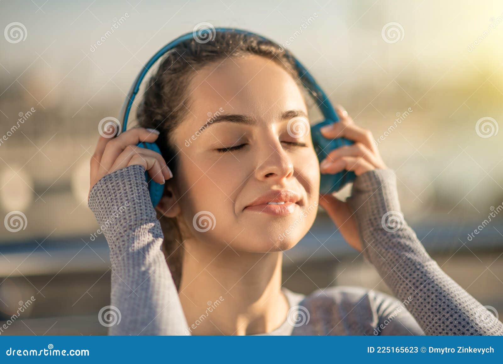 Menina ouvindo música em fones de ouvido na parede rosa. garota