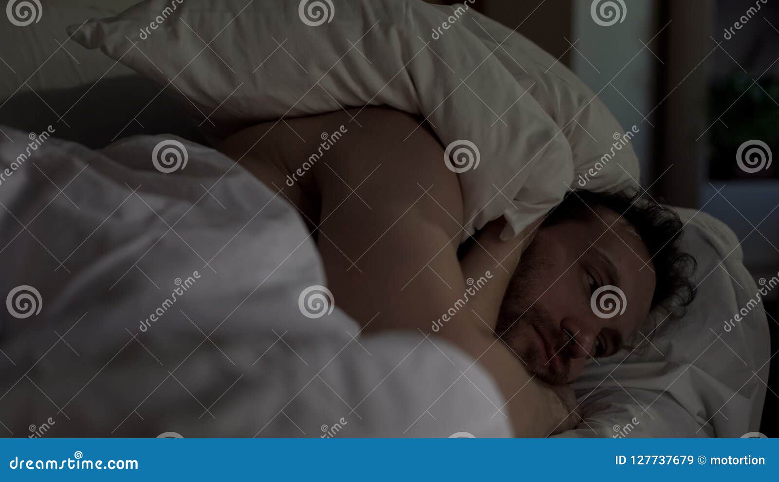 annoyed man tossing and turning in bed unable to fall asleep, noisy neighbors