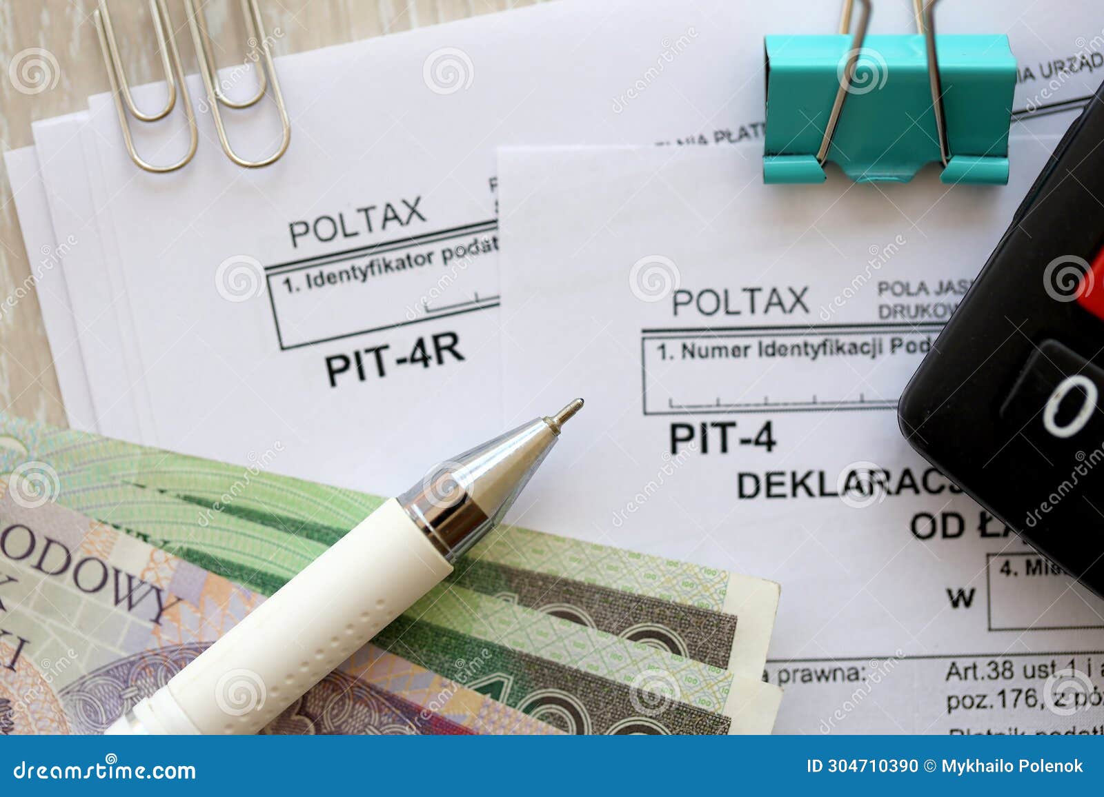 annual and monthly declarations of income tax advances, pit-4, pit-4r form on accountant table with pen and polish zloty