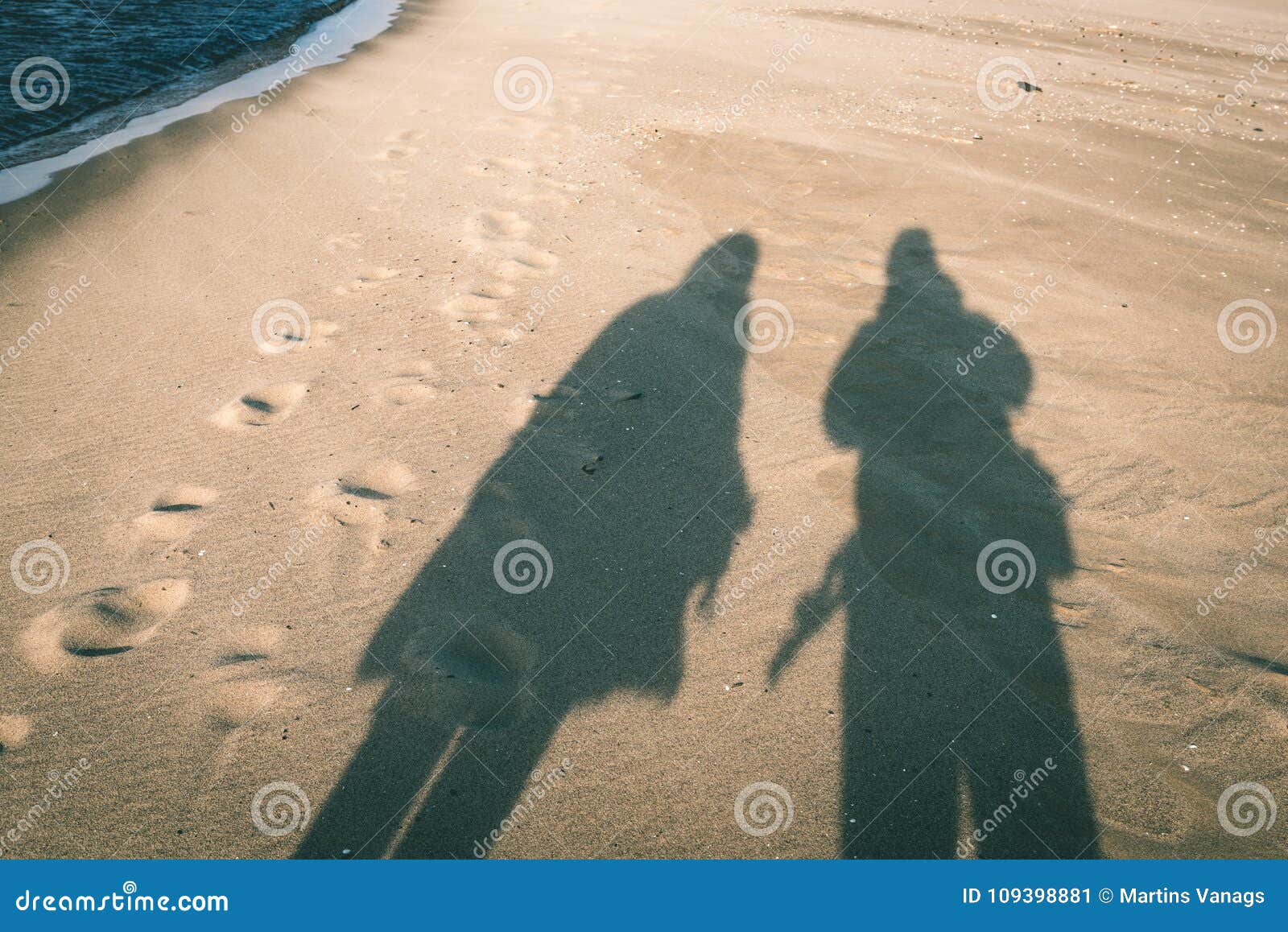 Anonimowy osoby odprowadzenie na piasku przy wietrzną plażą - rocznika effe. Anonimowy osoby odprowadzenie na piasku przy wietrzną plażą, opuszcza oceny w piasku Ryski, Latvia - rocznika skutek