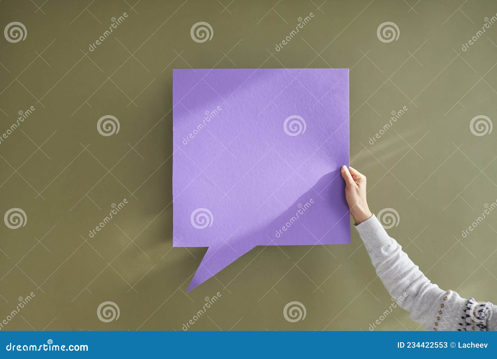 anonymous person holding purple square mockup message bubble on green background